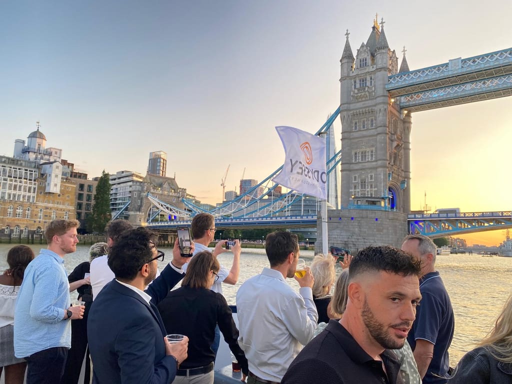 Guests on deck with the Odyssey flag as the boat passes Tower Bridge