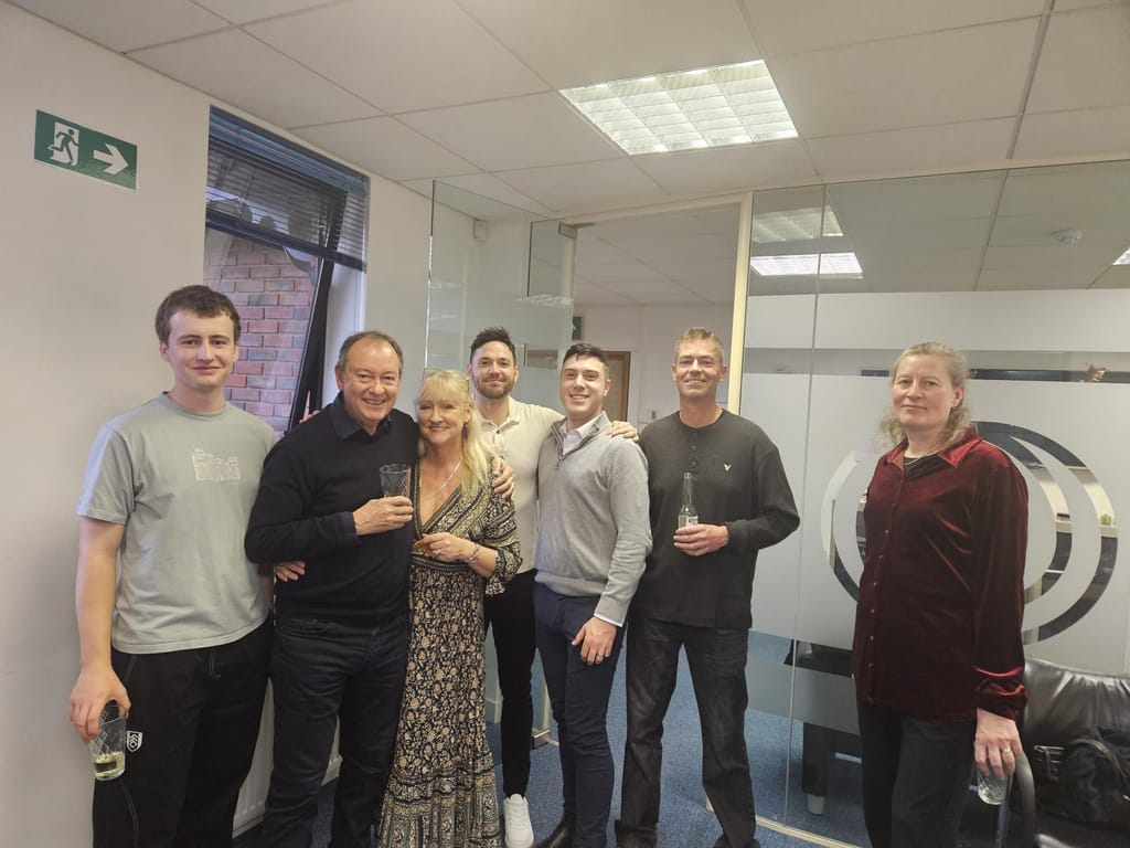 A group of colleagues with drinks in the office